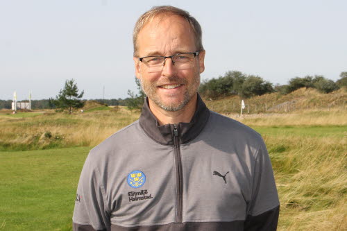 Porträttbild på medelålders man, utomhus i golfmiljö. Iklädd en grå sporttröja med logotyp för Elitmiljö Halmstad.